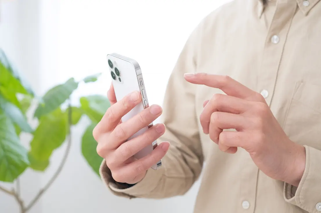 スマートフォンで問い合わせしている手の写真